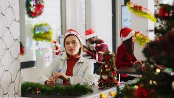 Portrait of happy woman in Christmas decorated workspace participating in vlog for marketing social media channel, talking about company values, enjoying xmas festive mood photo