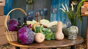 Various bio homegrown lettuce and cabbage next to jar of donations, colorful raw natural products on farmers market counter. Organic produce on stand and table with coins. Close up. photo