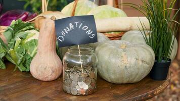 mesa con de cosecha propia vegetales y botellas de vino, tarro lleno con monedas para local donaciones mercado verde puesto con orgánico eco lechuga o repollo, crudo calabaza y calabacín. cerca arriba. foto