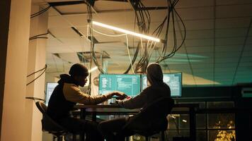Diverse people using trojan virus to exploit server vulnerability, hacking computer system late at night. Cyber criminals working with encryption to hack software and break security firewall. photo