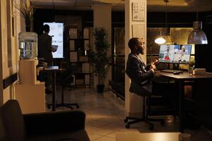 Businessman having online discussion with remote team, discussing marketing statistics during videocall meeting conference. Diverse colleagues working overhours at business strategy photo