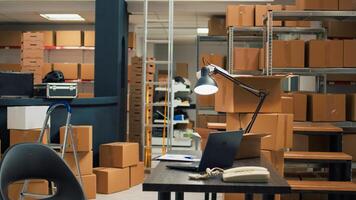 Storage room filled with merchandise packed in boxes, placed on shelves and racks in empty warehouse. Small business space used for shipping products and doing stock inventory. photo