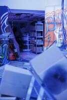 Damaged space filled with fluorescent neon lights, urban ghetto place with graffiti spray paint and purple bright light. Empty old abandoned building being illuminated and neglected. photo