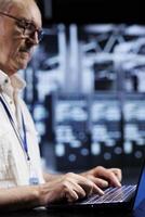 Aged qualified IT admin in data center providing dedicated VPN servers able to deliver enhanced privacy, encrypted sensitive data, online anonymity and stable internet connections to users photo