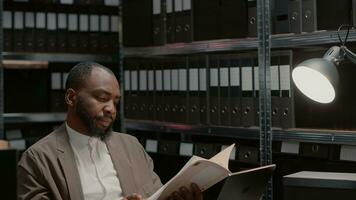 Law officer examining physical evidence in case files, using criminal records and information. Professional agent conducting private investigation, analyzing clues from archive folders. photo