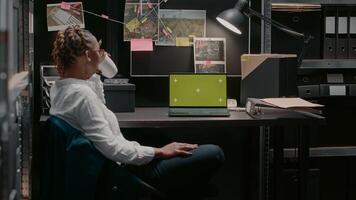Professional inspector using laptop with greenscreen, analyzing chroma key display and conducting police investigation. Private detective working with isolated mockup copyspace. photo