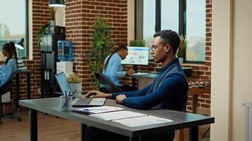 Company worker reading information at desk, working on annual data business results to obtain corporate development. Male employee examining analytics and creating management vision in office. photo