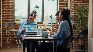 Employees reading annual data reports on files, examining analytics and results online. Business people working on company development with official information on documents, office workstation. photo