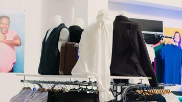 Shopping mall boutique filled with fashion tailoring, multiple racks with fashionable formal wear. Empty clothing showroom with trendy shirts on hangers, small business concept. photo