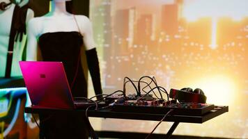 Empty DJ mixing station at nightclub, stage lights and disco music at discotheque for partying and clubbing. Dance floor at club with audio panel equipment used for dancing, nightlife. photo