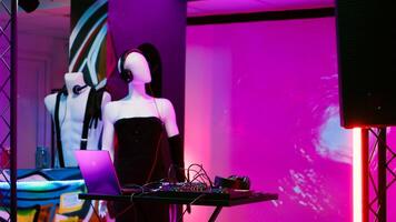 Mixing station panel on stage at bar, nightclub with empty dance floor and spotlights. Discotheque with live DJ music and alcohol, space used for modern funky party with disco lights for fun. photo