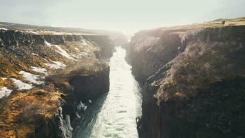 Drone shot of gullfoss waterfall in iceland, majestic cascade flowing between nordic canyon hills. Icelandic water stream falling down from cliffs. Slow motion. photo