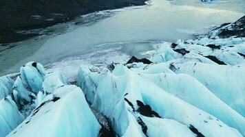 Drone shot of vatnajokull glacier cracks and crevasses with diamond frosty ice blocks, icelandic nature. Beautiful icebergs caves and frozen lake, nordic landscape. Close up. Slow motion. photo