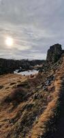 Massive mountain range and valley in arctic setting, Icelandic rocky and snowy peaks in majestic Thingvellir national park. Cliffs and hills in highlands with rock formations, scenic route. photo