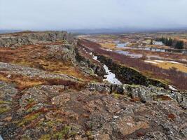 natural colinas con rock formaciones creando montaña pared en islandés thingvellir nacional parque, majestuoso tierras altas acantilados hecho de Roca. espectacular Islandia desierto en nórdico rocoso valle. foto