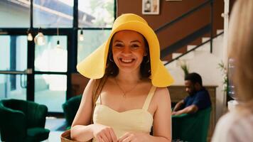 Hotel guest arriving at front desk and talking to receptionist about room reservation. Woman tourist dressed in summer clothes doing check in at tropical resort reception counter. photo