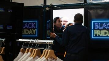 Customers demand shopping access on black friday, taking advantage of early hours to buy cheap clothes. Anxious crazy group of people pushing door and fighting with security agent. Handheld shot. photo