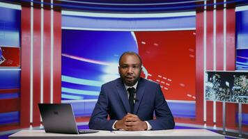 African american tv news anchor in studio presenting daily world events with newscast reportage, television content. Man journalist hosting media segment in newsroom, covering all essential topics. photo