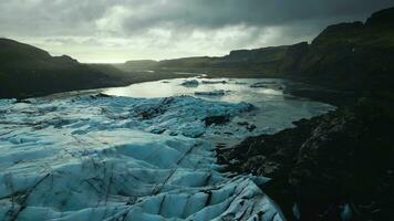 Drone shot of ice mass on frozen water, huge icy blocks floating on lake in iceland. Beautiful blue arctic landscapes and scenery with vatnajokull glacier cap, panoramic view. Slow motion. photo