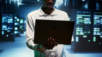 Electrician walking between hardware clusters in high performance computing server room, ensuring perfect operations conditions. Wireman monitoring data center electronics energy consumption, close up photo