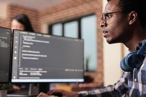 System engineer typing machine learning server code on computer, sitting at desk in software company. Programming engineer working on database system with coding script in it security agency. photo