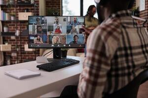 africano americano puesta en marcha empleado en Internet reunión con personas trabajando remoto desde hogar. selectivo atención en computadora pantalla con vídeo llamada software aplicación demostración equipo de colegas en conferencia. foto