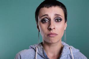 Upset unhappy woman crying after hearing of tragedy during studio shot standing on isolated background. Worried displeased adult person in tears having sadness emotion, mental breakdown photo