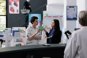 Drugstore customer complaining to pharmacist about purchased medicaments. Young asian woman and pharmaceutical assistant arguing about medical product price at pharmacy retail store photo