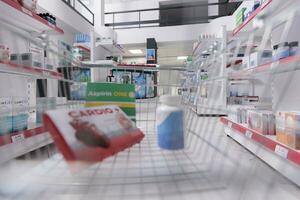 Store basket filled with pharmaceutics and pills ready to be buy by clients during checkup visit in drugstore. Pharmacy also carried a variety of other medical products, bandages and cold medicine. photo
