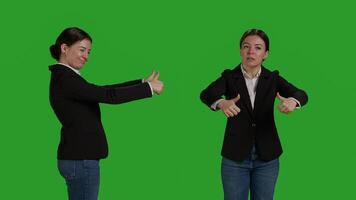 Close up of optimistic worker giving thumbs up over greenscreen backdrop, expressing like and okay sign in studio. Company employee in suit doing approval and agreement gesture. photo