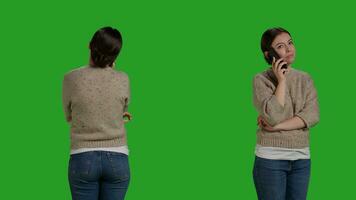 Close up of person talking on mobile phone remote call, using smartphone line to chat over full body greenscreen. Young cheerful model using telephone to talk to people in studio. photo