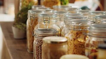 Close up on bulk products in recyclable glass containers used by zero waste supermarket to eliminate single use plastics. Local store pantry staples in sustainable packaging, zoom out shot photo