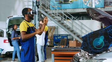 Serviceman in car service using advanced virtual reality technology to visualize motor turbine in order to fix it. Garage professional wearing VR glasses while servicing malfunctioning vehicle photo