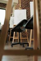 Art education. Empty classroom with wooden easels and chairs, creative studio space designed for sketch drawing classes for adults, nobody. Modern school of arts interior, no people photo