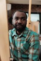 Creativity and self expression through art. Portrait of African American guy sitting at easel exploring creativity with drawing lessons, smiling young black man visiting painting class for adults photo