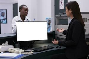 Reception worker manages patient records and schedules appointments typing medical information on computer with white isolated screen. Hospital staff working at health care treatment for patients photo