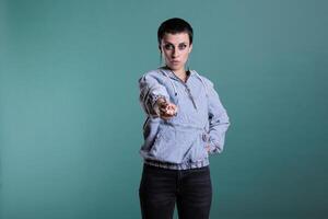 Displeased angry woman pointing index finger in front of camera screming during studio shot on isolated background. Upset nervous female having mental breakdown, disappointment expression photo