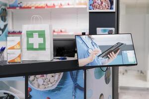 Empty drugstore counter desk equipped with supplements products and display showing drugstore adds, ready for clients to come and buy medical treatment. Health care service and concept photo