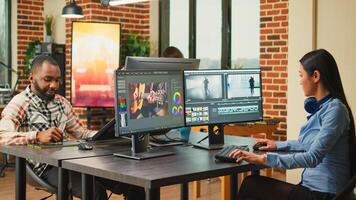 Professional artist working on film footage design with retouching software, using monitors in agency office. Post production house creative editor creating audio and video montage. photo