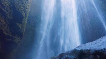 dentro hermosa islandés caso con alto montañas y majestuoso natural paisajes en Islandia. seljalandsfoss cascada con congelación agua y rocas, fluido abajo apagado acantilado. Mano disparo. foto