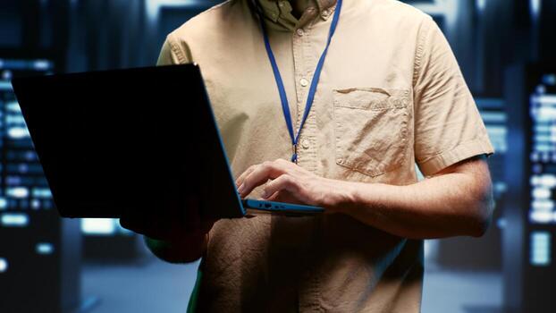 IT developer using laptop to audit energy consumption across server farm components and distributors. Programmer making sure data center hardware temperature sensors are performing flawlessly, close photo