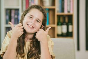 cute child little girl caucasian brown hair happy smiling two thumbs up like to reading and education in school photo