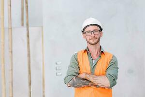 portrait hipster worker cosntruction engineer architect . builder foreman work in construction site smart arm crossed confident smile. photo