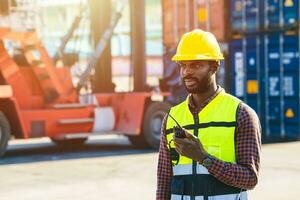 Logistic worker black male working in port cargo container yard operate  manage loading control photo