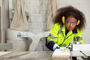 woman work in plywood wood panel modern furniture factory. safety lady worker in wood workshop. african black women young in joiner industry working people photo