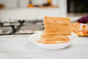 de cerca rebanado un pan sábana pila apilado en blanco plato en el cocina foto