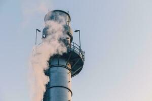 poder estación limpiar moderno fábrica petróleo petroquímico industria edificio al aire libre paisaje con grande Chimenea liberando fumar. foto