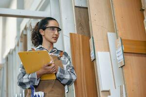 staff working in wood furniture industry factory checking inventory of plywood wooden board type material in stock wood store warehouse. photo