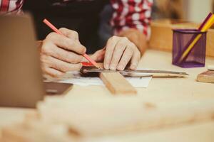 closeup wood worker carpenter working making hand made craft diy wood furniture job. photo