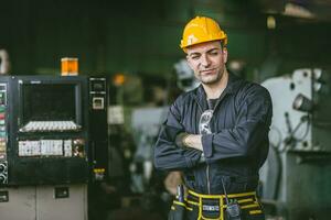 retrato ingeniero masculino técnico experto hábil mayor personal trabajador confidente en pie brazo cruzado con maquinaria fábrica foto